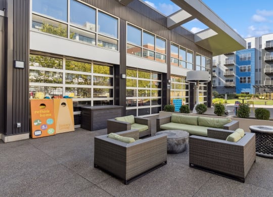 an outdoor patio with couches and tables in front of a building at Bakery Living, Pittsburgh, PA