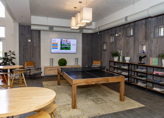 a game room with a ping pong table and a flat screen tv at Bakery Living in Pittsburgh, PA 15206