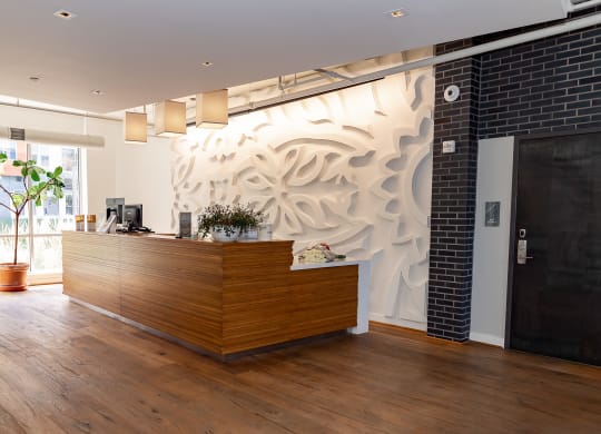 a view of the reception desk with a large mural on the wall behind it at Bakery Living in Pittsburgh, PA 15206