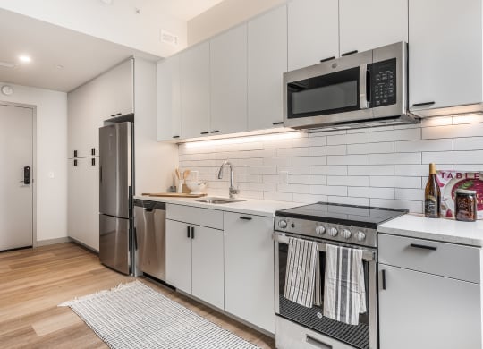a kitchen with white cabinets and stainless steel appliances and a microwave at The Commonwealth Building, Pittsburgh, 15222
