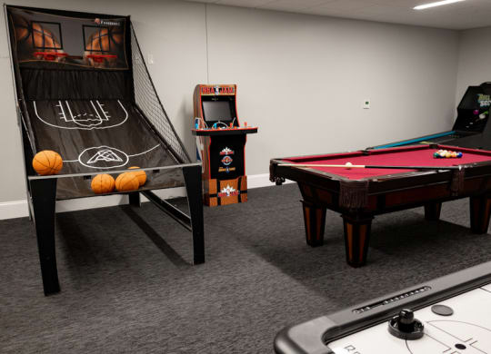 a games room with a pool table shuffleboard and arcade games at The Washington at Chatham, Pittsburgh, PA