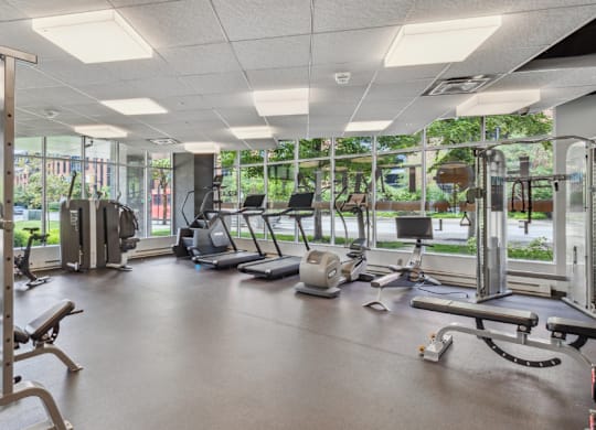 A gym with a variety of equipment including treadmills, weights, and exercise machines.