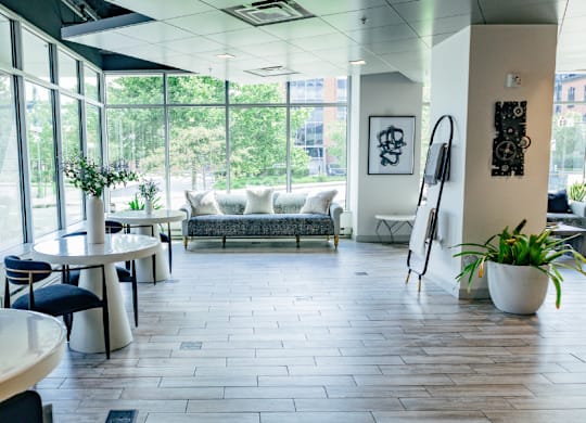 A modern office lobby with a large window overlooking the trees.