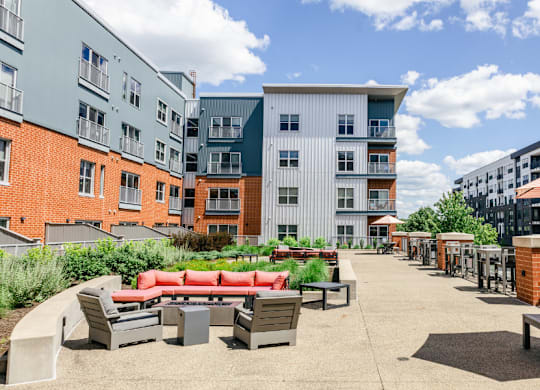 A sunny day at a courtyard with a red bench and a picnic table.