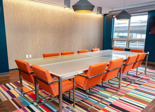 a conference room with a long table and orange chairs