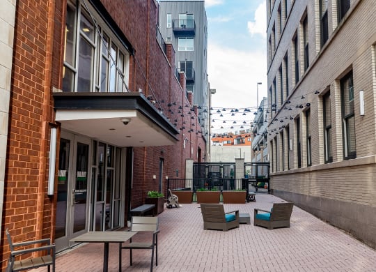 a courtyard with chairs and tables in front of a brick building at Walnut on Highland, Pittsburgh, PA