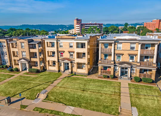an aerial view of a row of apartment buildings with a grassy area in front of them at University Commons Apartments, Oakland, Pittsburgh