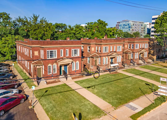 a large brick building with a grassy area in front of it at University Commons Apartments, Oakland, Pittsburgh