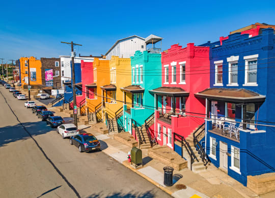 a row of colorful buildings on a city street at University Commons Apartments, Oakland, Pittsburgh