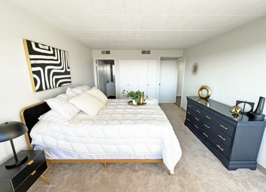 a bedroom with a large white bed and a black dresser at Walnut Towers at Frick Park, Pittsburgh