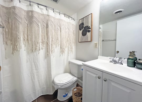 a bathroom with a white sink and toilet and a white shower curtain at Walnut Towers at Frick Park, Pennsylvania 15217