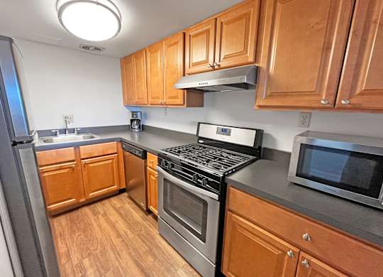 A kitchen with wooden cabinets and stainless steel appliances at Walnut Towers at Frick Park, Pittsburgh, 15217