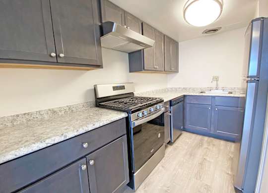 A kitchen with a stove top oven and a refrigerator at Walnut Towers at Frick Park, Pennsylvania