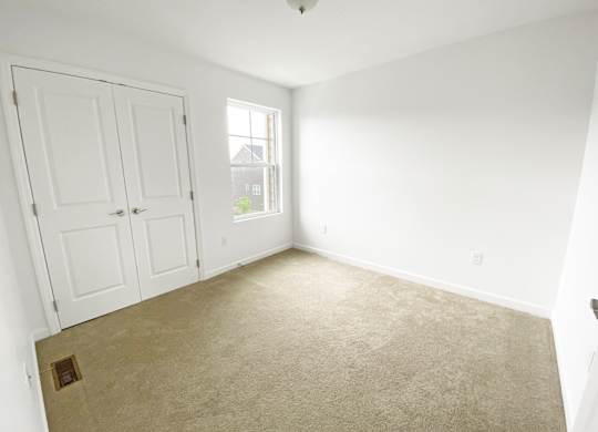 A room with a carpeted floor and a window. at Highland Village, Ross Township, Pittsburgh, PA 15229