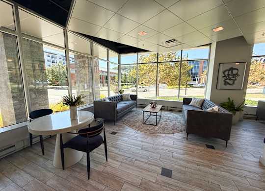 A modern living room with a large table and chairs. Hot Metal Flats apartments, Southside Pittsburgh, PA