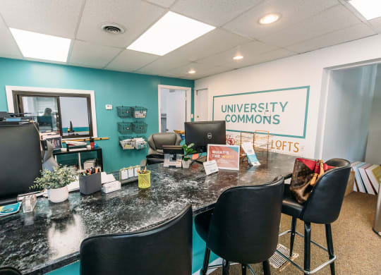 an office with a long desk with black chairs and a sign that says university commons at University Commons Apartments, Oakland, Pittsburgh