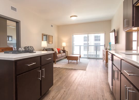 a kitchen and living room with a sliding glass door to a balcony Hot Metal Flats apartments, Southside Pittsburgh, PA