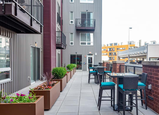 an outdoor patio with tables and chairs at the melrose apartments