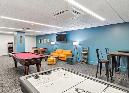 A room with a pool table, couch, and television. at The Washington at Chatham, Pennsylvania, 15219