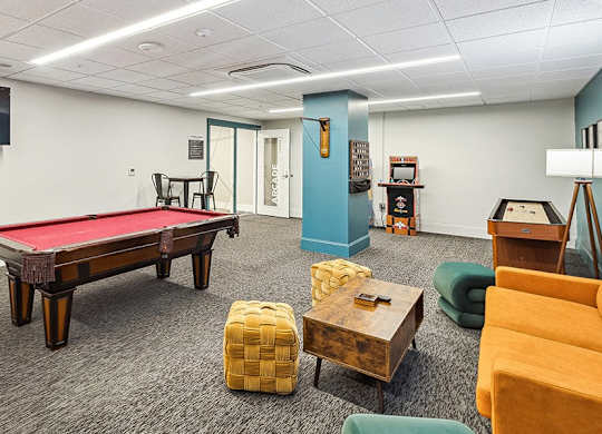 A room with a pool table, chairs, and a television. at The Washington at Chatham, Pennsylvania, 15219