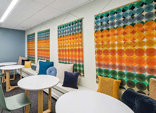 A room with tables and chairs and a wall of circles. at The Washington at Chatham, Pennsylvania, 15219
