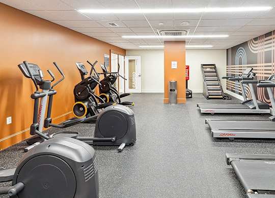 A gym with treadmills, elliptical machines, and stationary bikes. at The Washington at Chatham, Pennsylvania, 15219