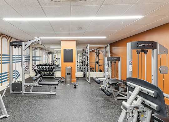 A gym with a variety of equipment including weights and weight machines. at The Washington at Chatham, Pennsylvania, 15219