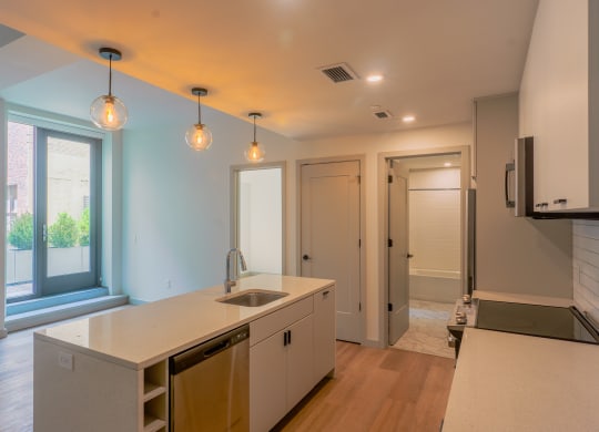 a kitchen with an island and a door to a hallway at The Commonwealth Building, Pittsburgh, 15222