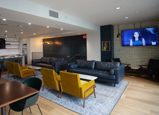 a living room with couches and chairs and a tv at The Commonwealth Building, Pittsburgh, 15222