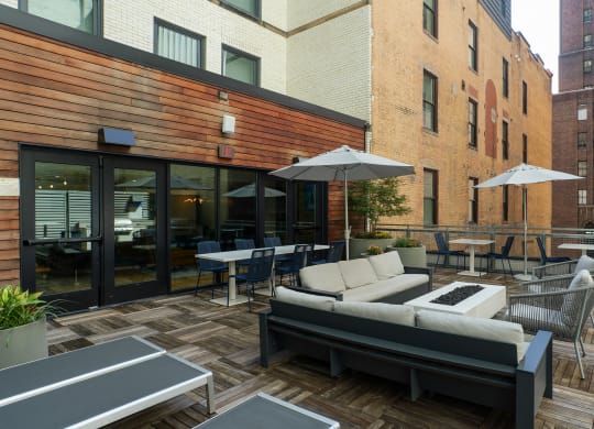 a patio with couches tables and chairs and umbrellas at The Commonwealth Building, Pittsburgh, 15222