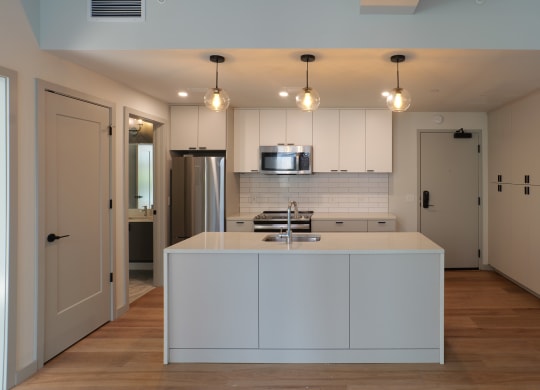 a kitchen with white cabinets and a white counter top in a house at The Commonwealth Building, Pittsburgh, 15222