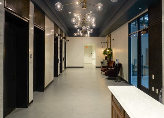 a long hallway with a marble counter top and a row of black doors at The Commonwealth Building, Pittsburgh, 15222