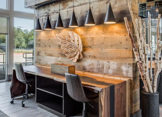 a home office with reclaimed wood walls and a wooden desk with black chairs at Trailhead, Austin, TX