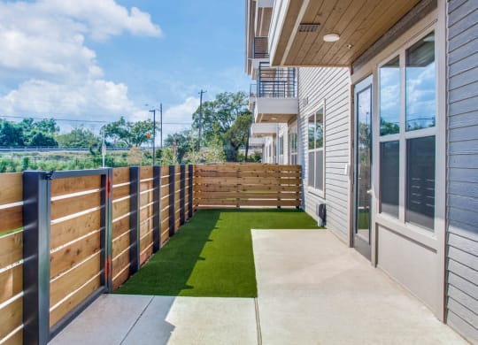 a yard with artificial grass and a wooden fence at Trailhead, Austin, TX 78721
