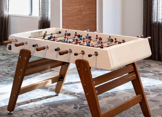 a foosball table in a living room with a dart board