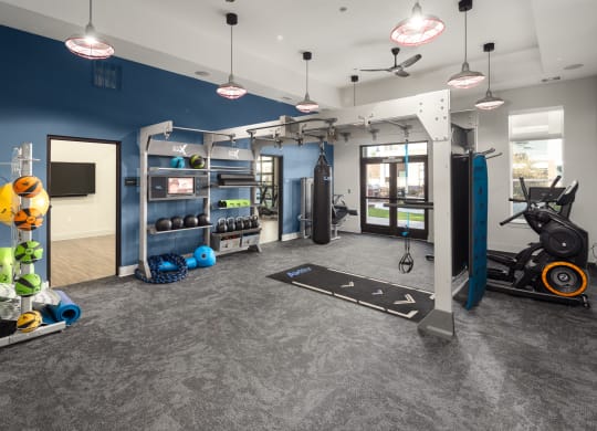 a gym with weights and other exercise equipment in a building with blue walls