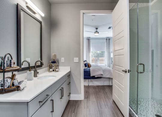 a bathroom with a large mirror and a glass shower door at Trailhead, Texas, 78721
