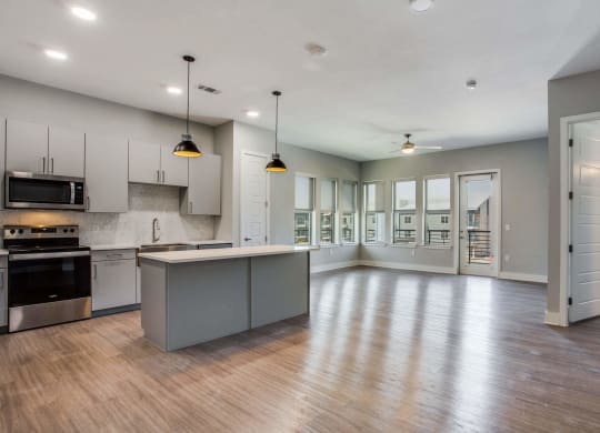a kitchen and living room with hardwood floors and gray walls at Trailhead, Austin Texas