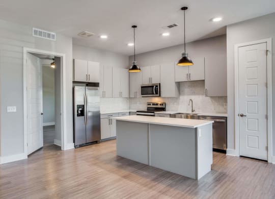 a kitchen with white cabinets and stainless steel appliances at Trailhead, Austin, 78721