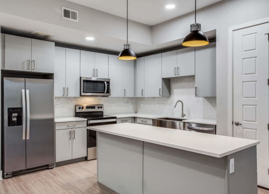 a kitchen with white cabinets and stainless steel appliances at Trailhead, Texas