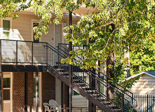 A Tree Branch is Hanging Over a Metal Railing on a Staircase at Fair Oaks Apartments, Little Rock, AR, 72204