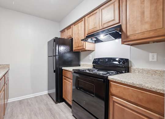 A Kitchen With Wooden Cabinets at Fair Oaks Apartments, Little Rock, Arkansas