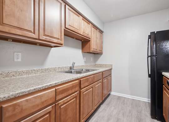 A Kitchen With Black Refrigerator at Fair Oaks Apartments, Little Rock, AR