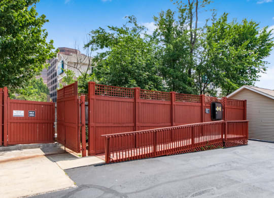 a red fence in front of a house with a parking lot
