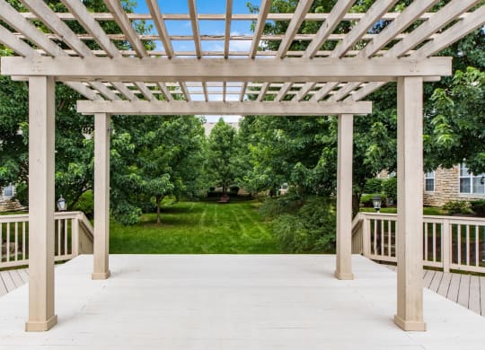 the deck has a pergola over it and a view of the yard