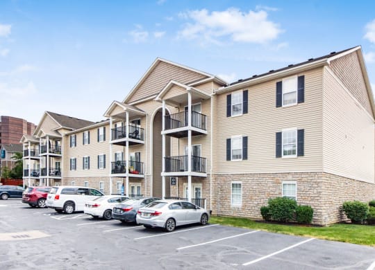 an apartment building with cars parked in a parking lot