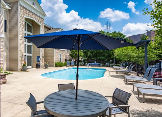our apartments have a pool and patio with chairs and umbrellas