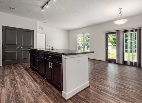 A kitchen with dark wood cabinets and a white island. at River View at Bexley Apartments, River View at Bexley, OH, 43209