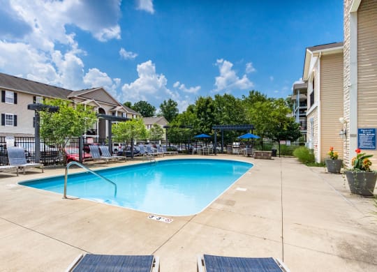 our resort style swimming pool is surrounded by our apartments and has a blue sky background