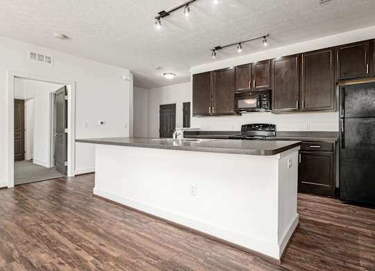 A kitchen with white countertops and dark brown cabinets. at River View at Bexley Apartments, Ohio